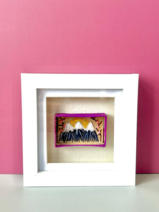 Vintage matchbox embroidered with a mountain scene reminiscent of Mount Fuji