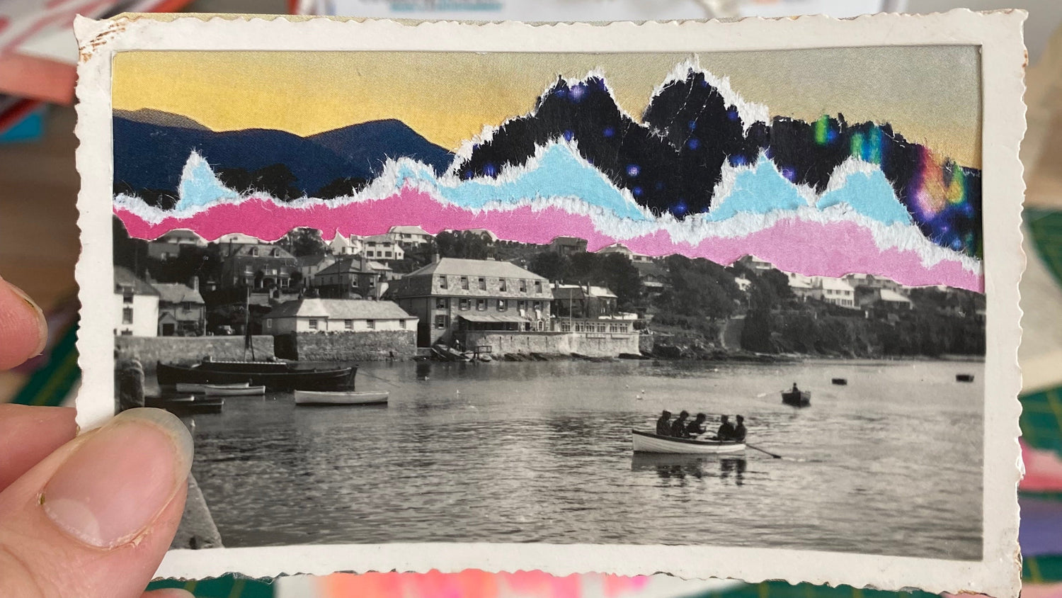 Hand holding a small vintage-style photo with colorful borders against a blurred background